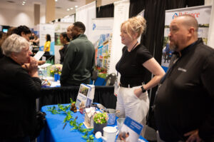 People at display tables interact with the public.